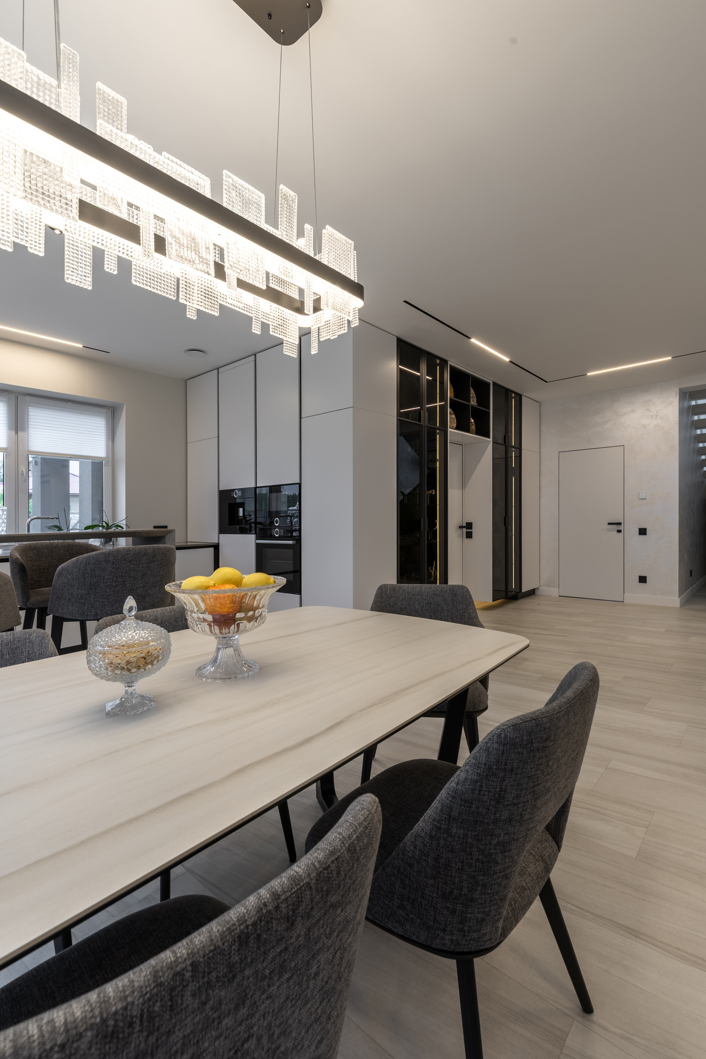 Vertical view of luxury dining area with designer crystal chandelier